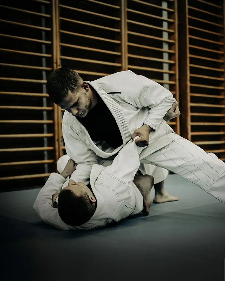 Dois atletas de kimono treinando no tatame