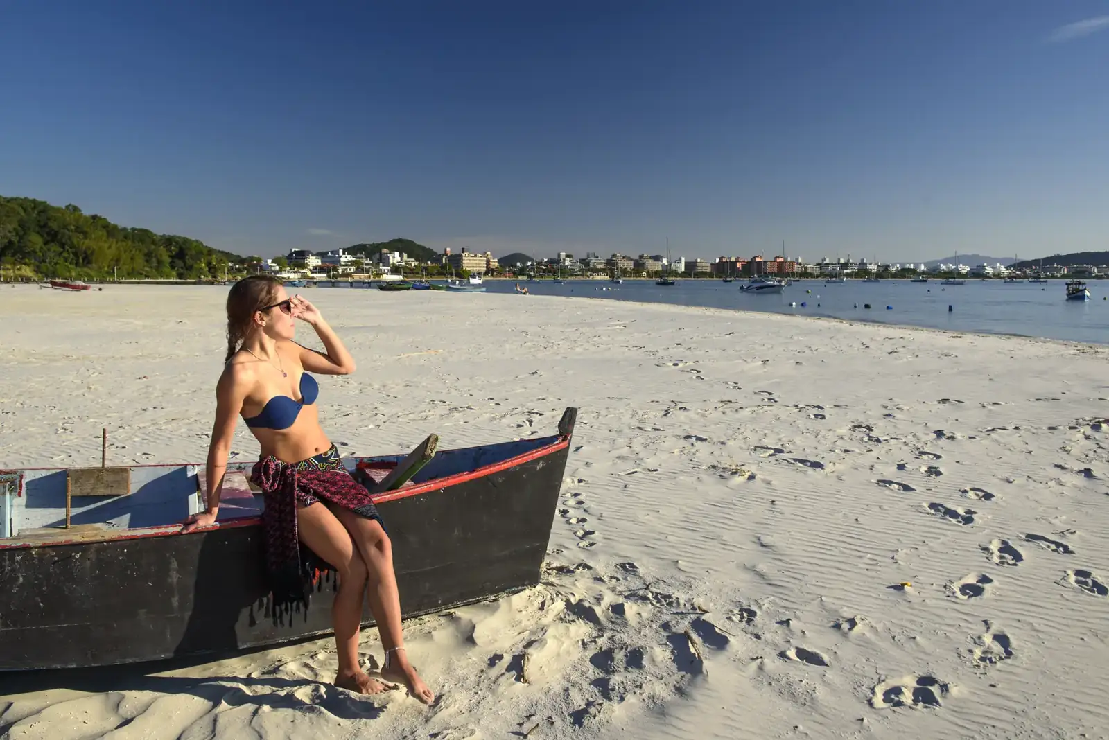 Praia de areia clara com barco de pescador em Florianópolis